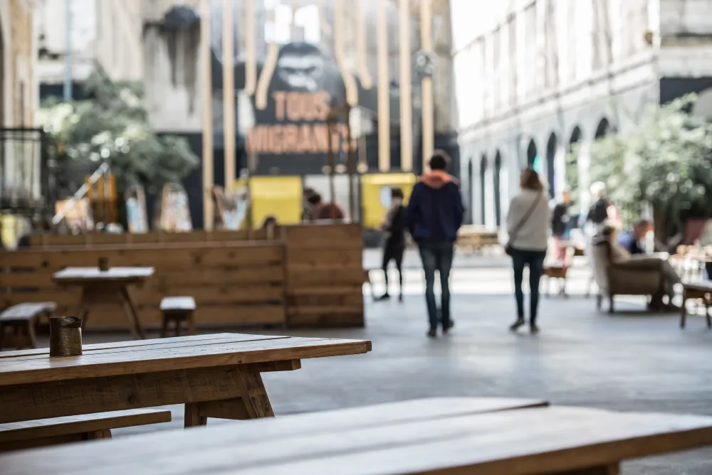 Darwin, éco-système alternatif à Bordeaux. Vue de tables, fauteuils, et quleques personnes floues en arrière plan.