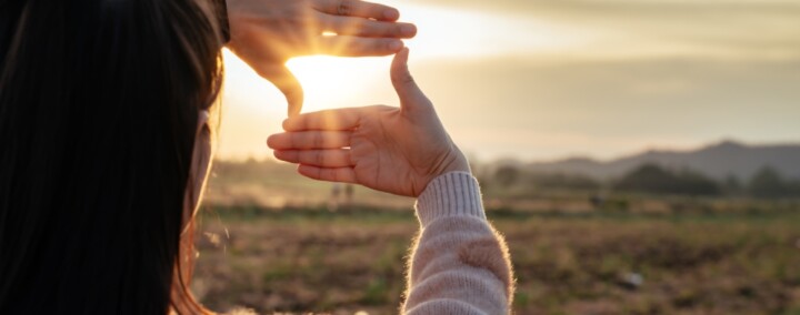 femme regardant un coucher de soleil à la campagne