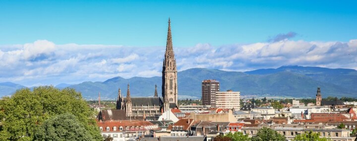 vue de mulhouse avec cathédrale et montagnes au fond